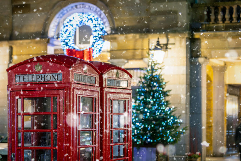 Deux cabines de téléphone rouge avec un sapin de noël dans le fond.