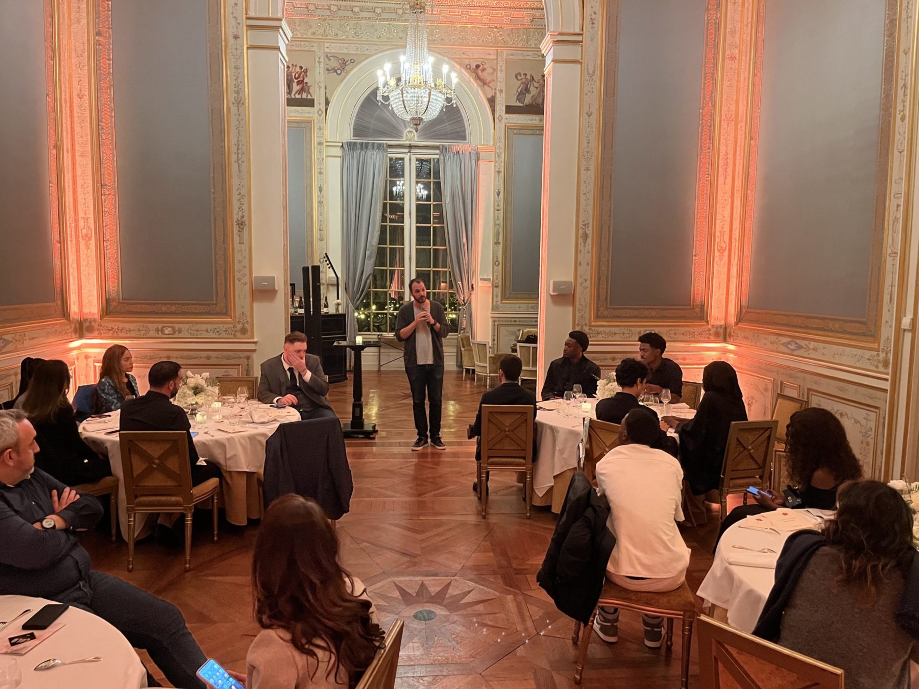 Gala des influenceurs à Paris une personne parle avec le micro devant les invités qui sont assis à différentes tables