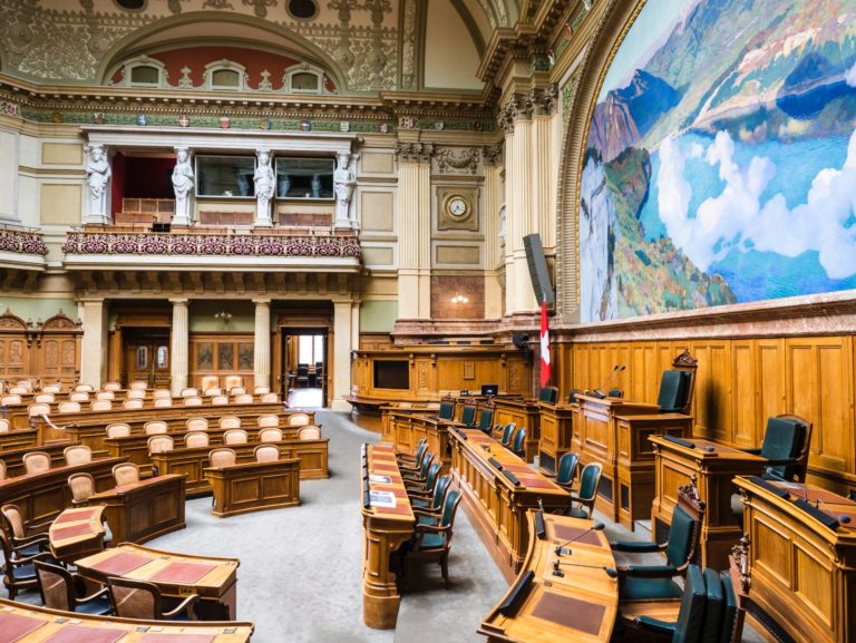 Prise de vue partielle de l'intérieur du Parlement suisse. Les sièges sont vides.