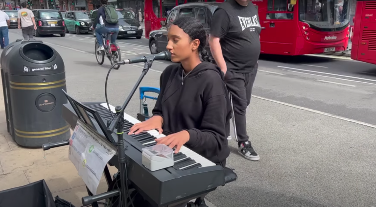 Harmonie London, une chanteuse de rue chrétienne entrain de chanter derrière son piano dans les rues de Londres