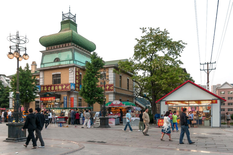 les passants se promènent tranquillement dans une rue piétonne de Dalian, en Chine