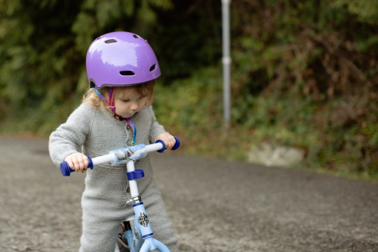 Une toute petite fille tente de faire du tricycle