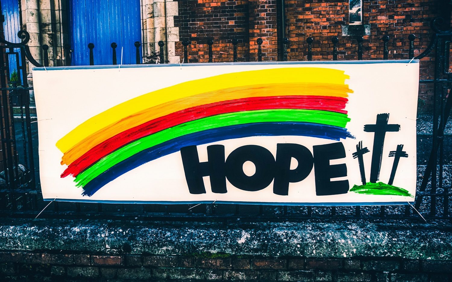 Un panneau "Hope" (Espoir) avec trois croix et un arc-en-ciel sur la grille d'une Eglise presbytérienne à Belfast