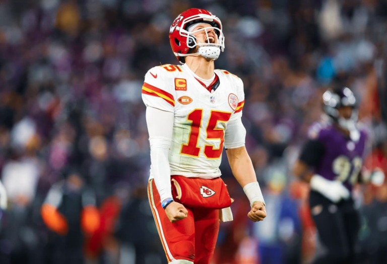 Patrick Mahomes, joueur de football américain, en tenu sur le terrain, les points serrés entrain de crier