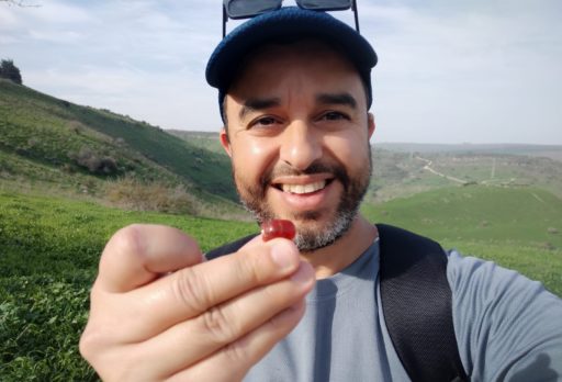 Un homme avec des lunettes de soleil sur la tête tient le sceau entre ses doigts