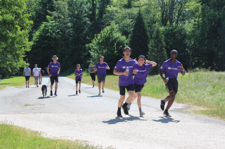 Des participants au défi sportif de portes ouvertes entrain de courir avec des tee-shirt de l'ong