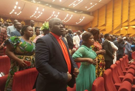 Des chrétiens évangéliques ivoiriens debout dans une salle de congrès