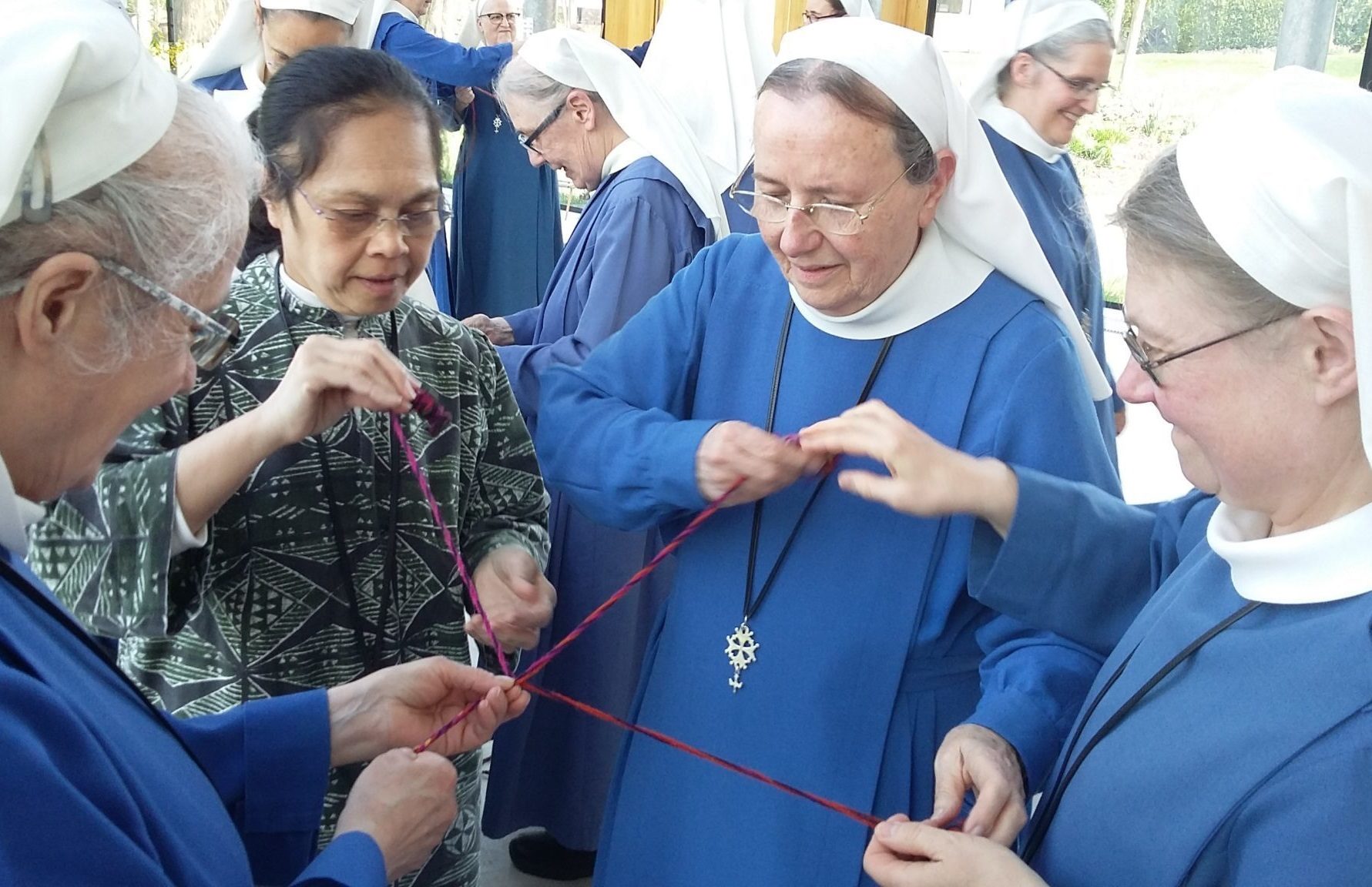 Les Diaconesses de Reuilly avec une tenue bleue, l'une d'elles arbore une croix huguenote en pendentif