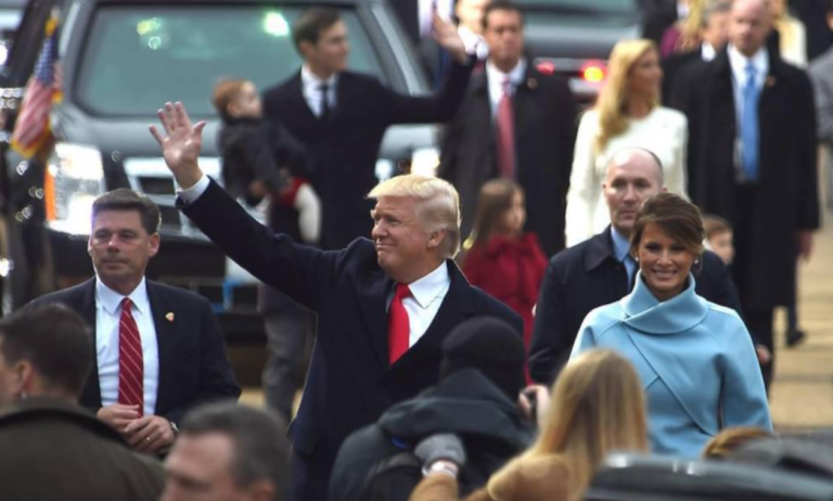 Donald Trump salue la foule tandis qu'il marche sur un tapis rouge