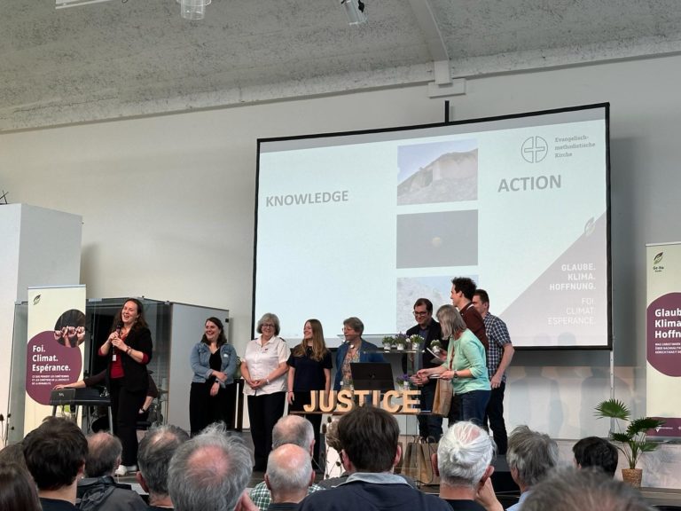 Devant des rangées d'auditeurs assis dans une salle, plusieurs personnes sur une estrade répondent aux questions d'une oratrice qui tient un micro.