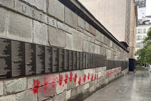 Des traces de mains rouges sont taguées sous les noms du Mur des Justes de Paris