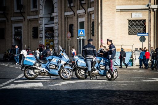 Deux policiers italiens discutent à côté de leurs motos bleues