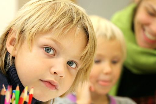 Un garçon et une fille avec une enseignante au second plan