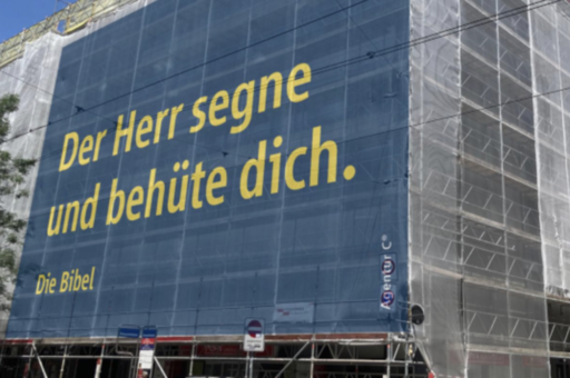 Le verset : «Que le Seigneur te bénisse et te garde» sur une méga-affiche installée sur un échafaudage alors que l'immeuble est en travaux