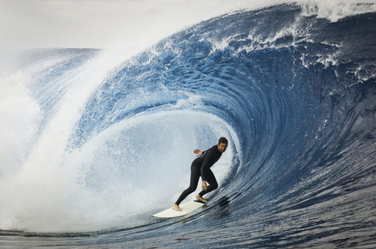 Un surfeur au creux d'une grosse vague