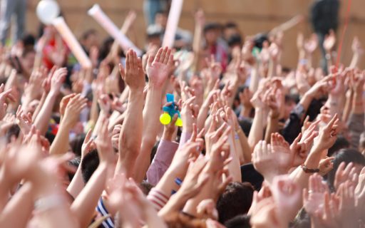 Photo d'une multitude de mains levées en signe de prière.
