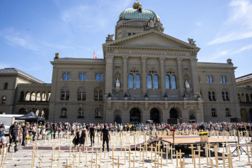 Devant le Palais fédéral, de nombreuses personnes sont rassemblées et des croix symbolisant la mort des chrétiens persécutés sont disposées sur toute la place.
