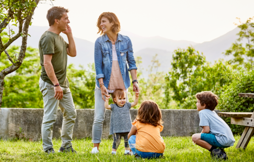 Une famille de cinq, deux parents et trois jeunes enfants, s'amuse dans un parc