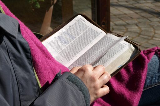 Une femme lit la Bible et tourne une page