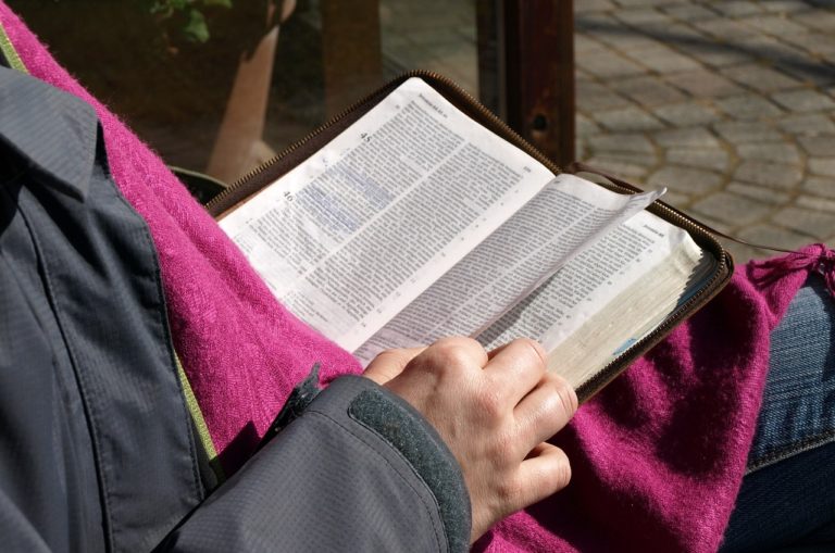 Une femme lit la Bible et tourne une page