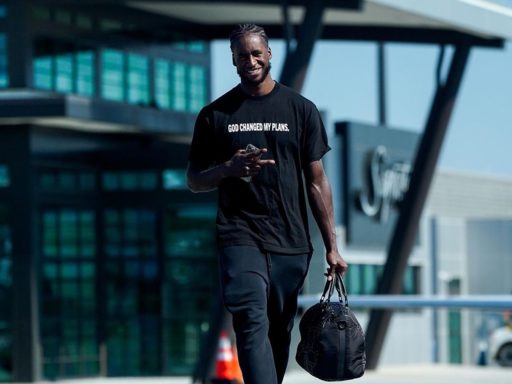 AJ Griffin vêtu d'un T-shirt "God changed my plans (Dieu a changé mes projets) et un sac de sport au bout du bras