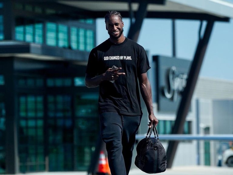 AJ Griffin vêtu d'un T-shirt "God changed my plans (Dieu a changé mes projets) et un sac de sport au bout du bras