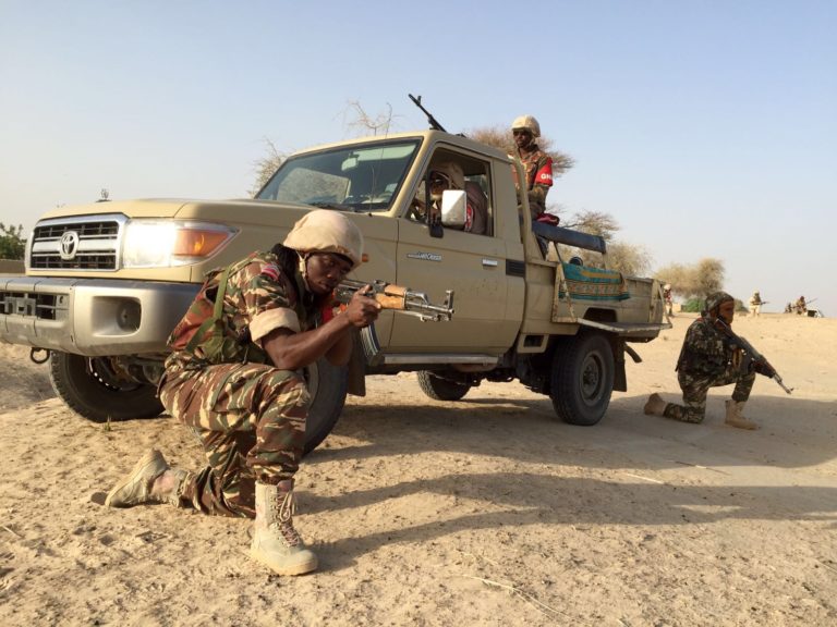 Des soldats de l'armée du Nigéria en position de tirs près d'un véhicule