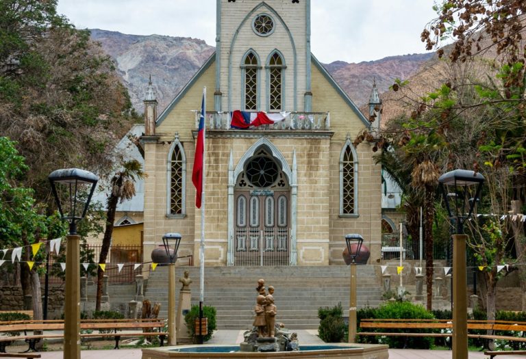 Une fontaine sur une place, avec une Eglise en second plan