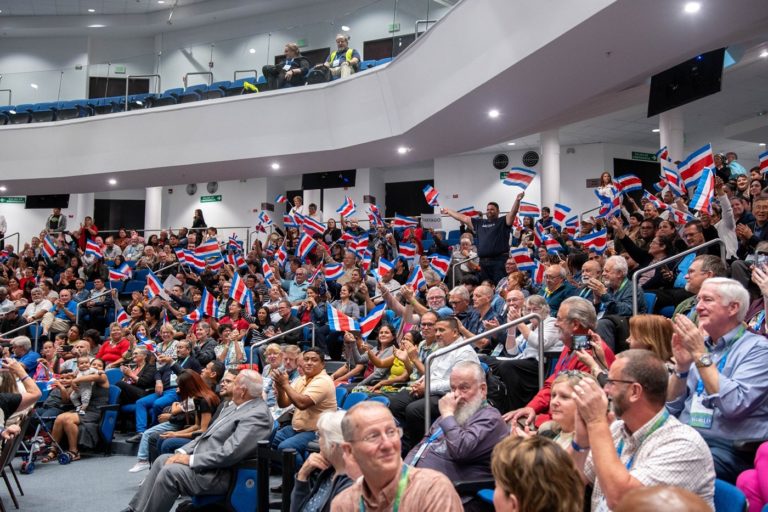 Des personnes assises sur des sièges agitent des drapeaux du Costa Rica