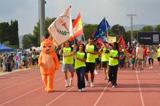 Des jeunes et une mascotte portent des drapeaux