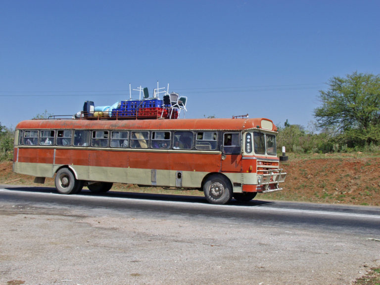Un bus orange roule sur une route d'Afrique
