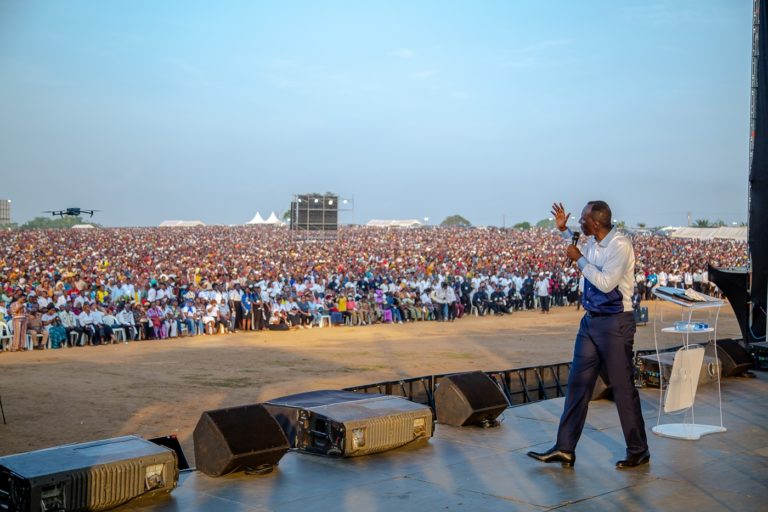 Chris Ndikumana parle et fait des gestes devant une grande foule