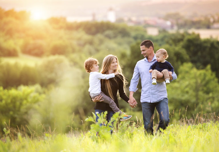 Un couple se promène avec ses deux enfants à la campagne