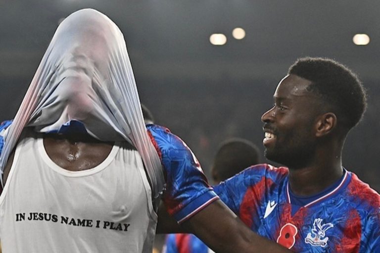 Marc Guehi regarde son coéquipier qui a soulevé son maillot et laisse apparaître le message "Je joue dans le nom de Jésus"