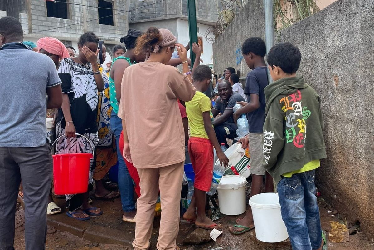 Des habitants de Tsingoni (Mayotte) avec des seaux tentent de s'approvisionner en eau après le passage du cyclone