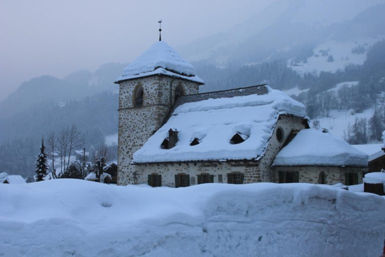 Vue extérieur du temple de Vers-l'Eglise, recouverte et entourée de neige, avec un léger brouillard sur les hauteurs
