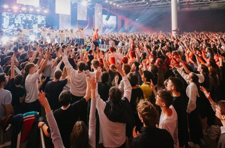 Des milliers de jeunes lèvent les bras vers le ciel lors d'un moment d'adoration au PraiseCamp à Bâle
