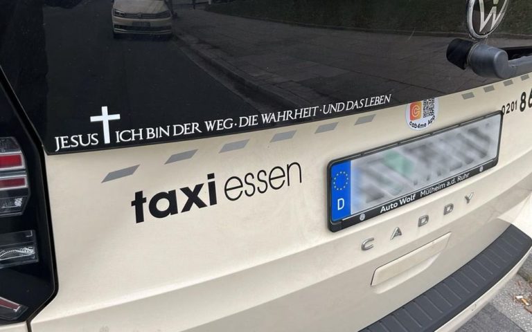 Un verset biblique collé sur la fenêtre arrière d'un taxi d'Essen immatriculée en Allemagne