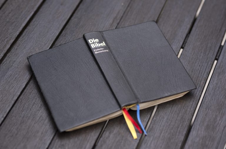 Une bible allemande posée sur un plancher en bois
