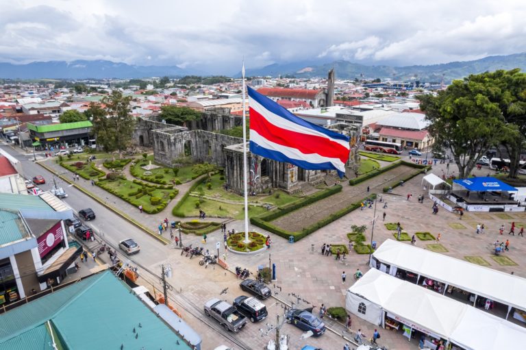 Un drapeau du Costa Rica flotte dans le ciel et haut dessus d'une basilique en ruines