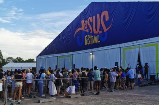 Des personnes font la queue pour entrer sous une grande tente du Jesus Festival