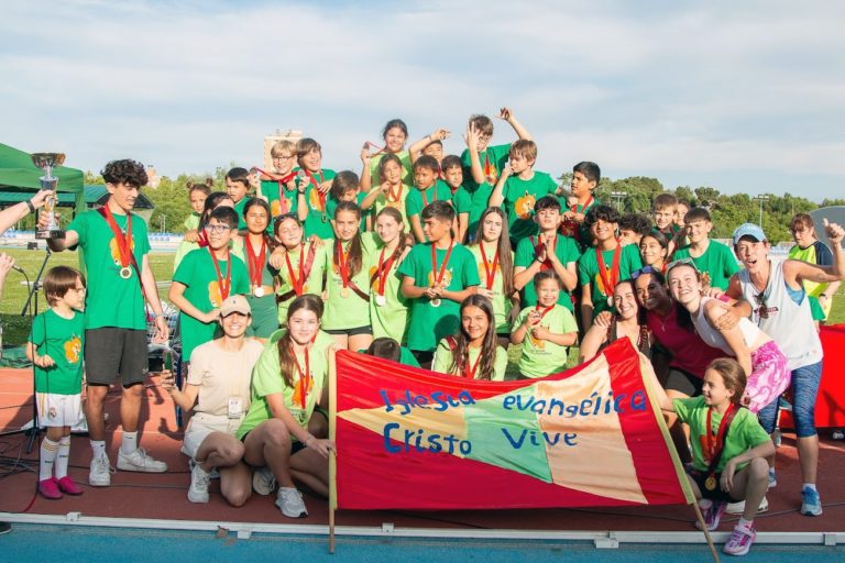 Des adolescentes et adolescents avec des maillots verts prennent la pose après leur victoire lors de la 23e olympiade évangélique de Madrid