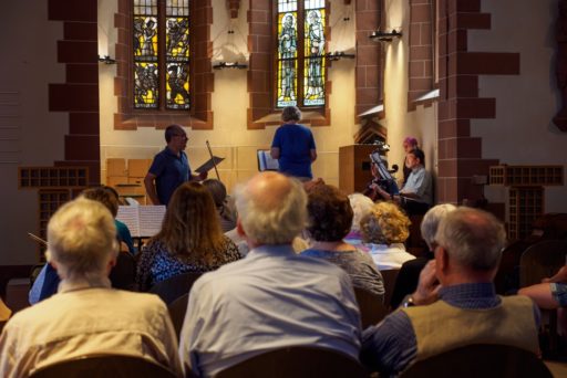 des personnes âgées assistent à un concert dans une Eglise protestante