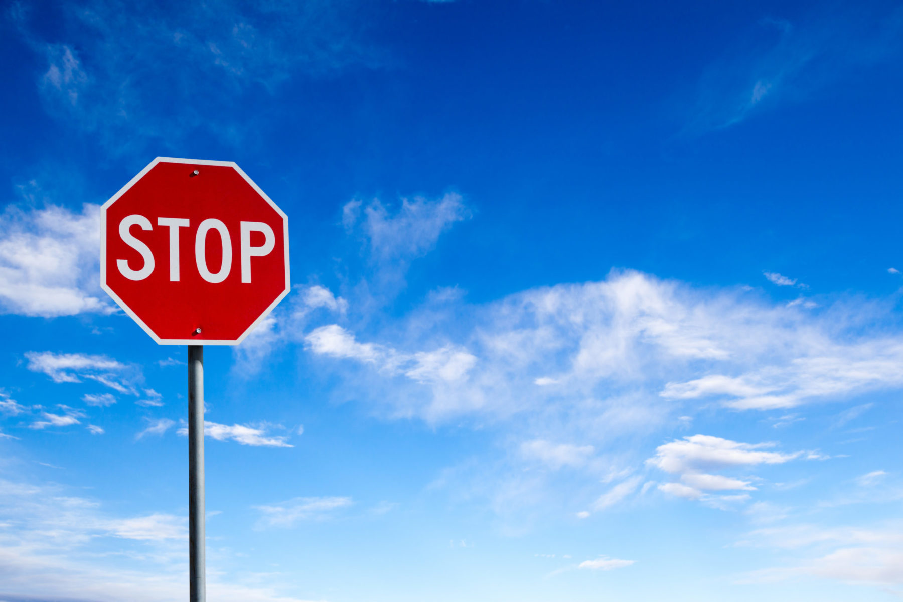 Un panneau "stop" photographié avec un ciel bleu en arrière-plan