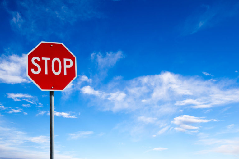 Un panneau "stop" photographié avec un ciel bleu en arrière-plan