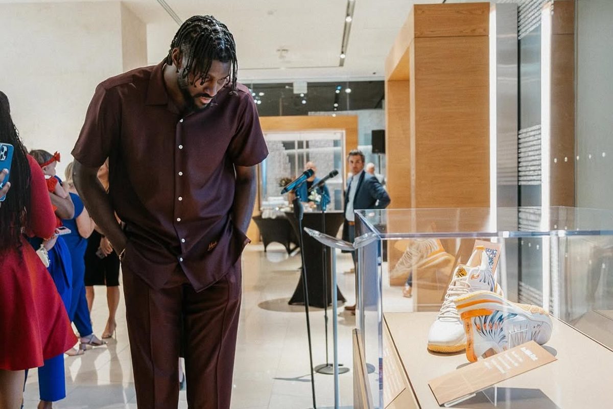 Jonathan Isaac observe sa paire de baskets Judah 1 mise sous verre dans le Musée de la Bible