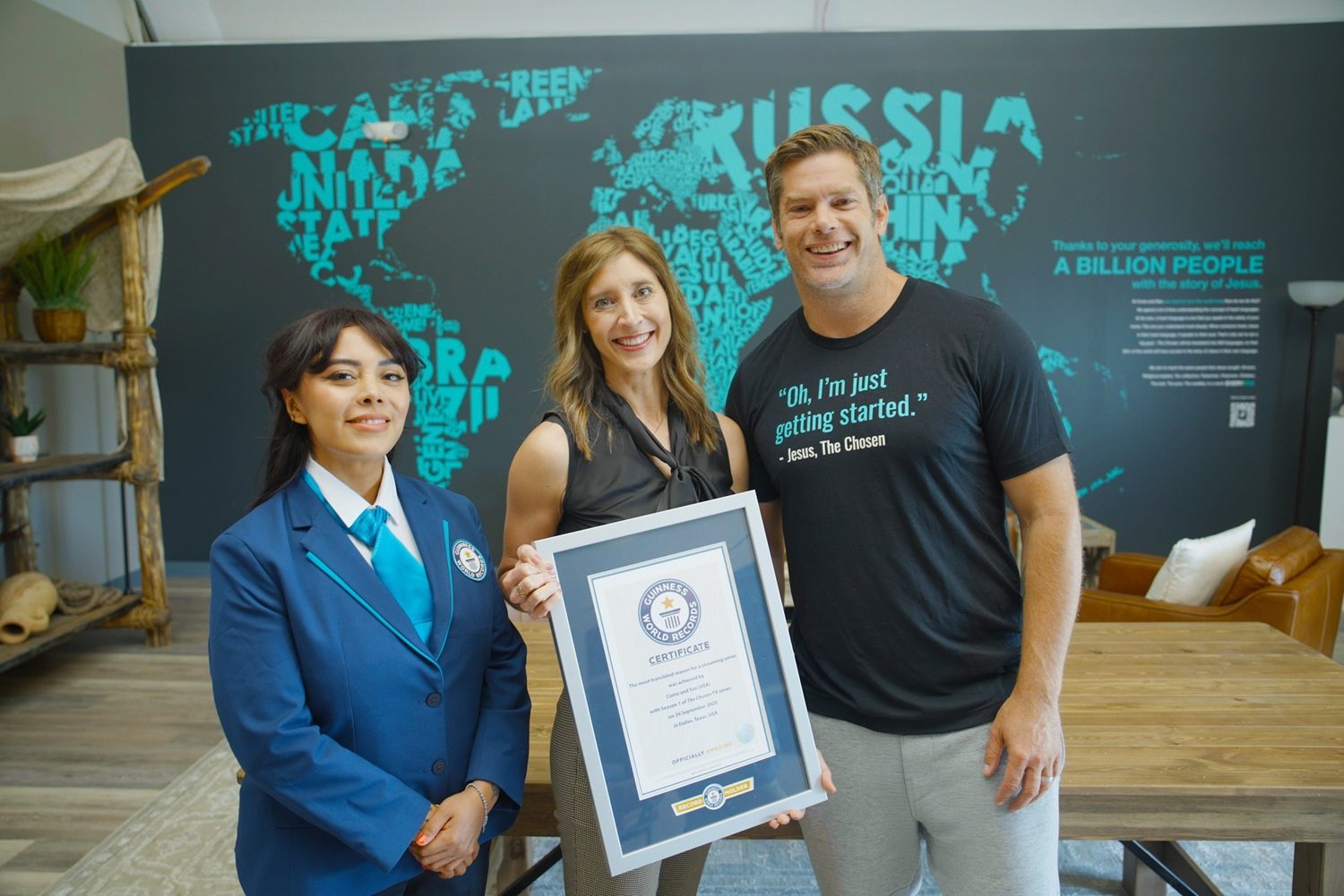 Une femme tient un tableau avec le certificat Guinness des record. A ses côtés, Dallas Jenkins, producteur et réalisateur de The Chosen