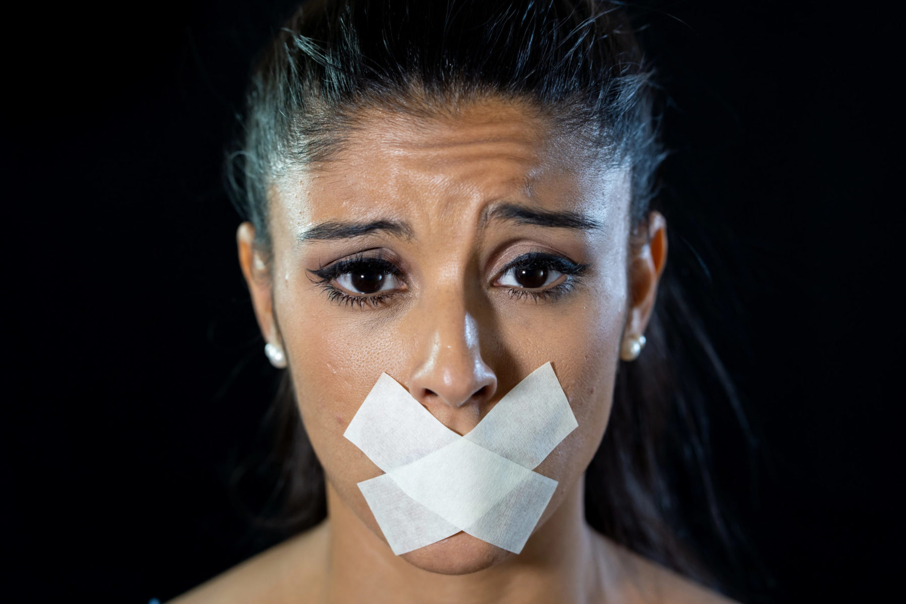 Une femme avec du scotch sur la bouche, symbolisant la traite d'être humains.