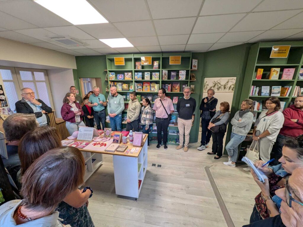 Un groupe de personnes se tient dans la librairie l'Espérance