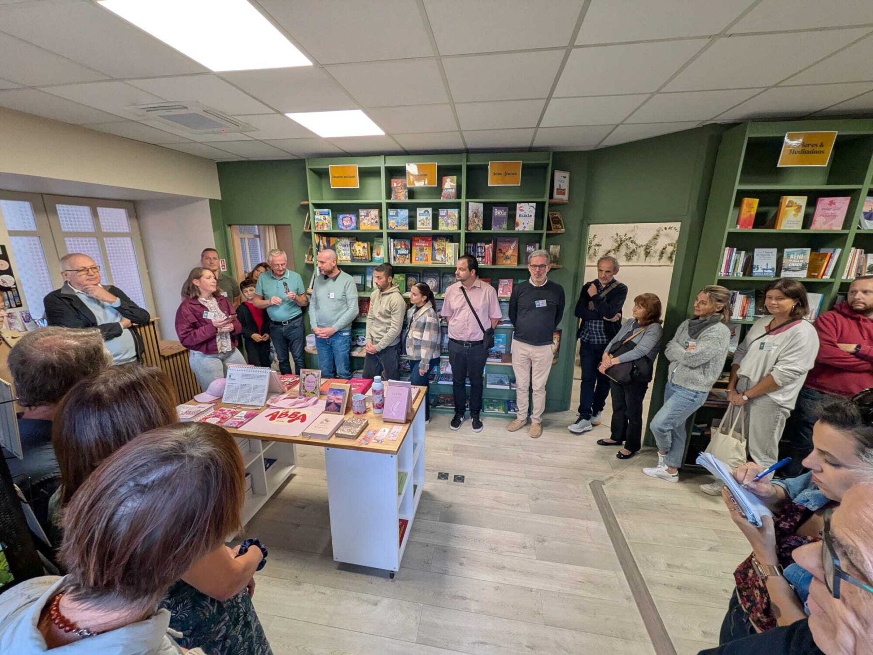 Un groupe de personnes se tient dans la librairie l'Espérance